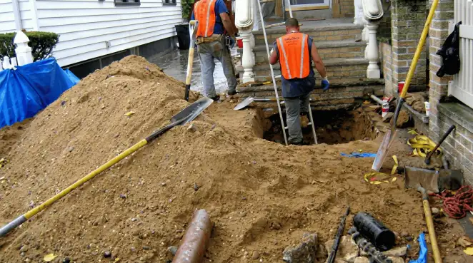 Contractors performing foundation protection and exterior drainage excavation near residential home steps in Boise, ID